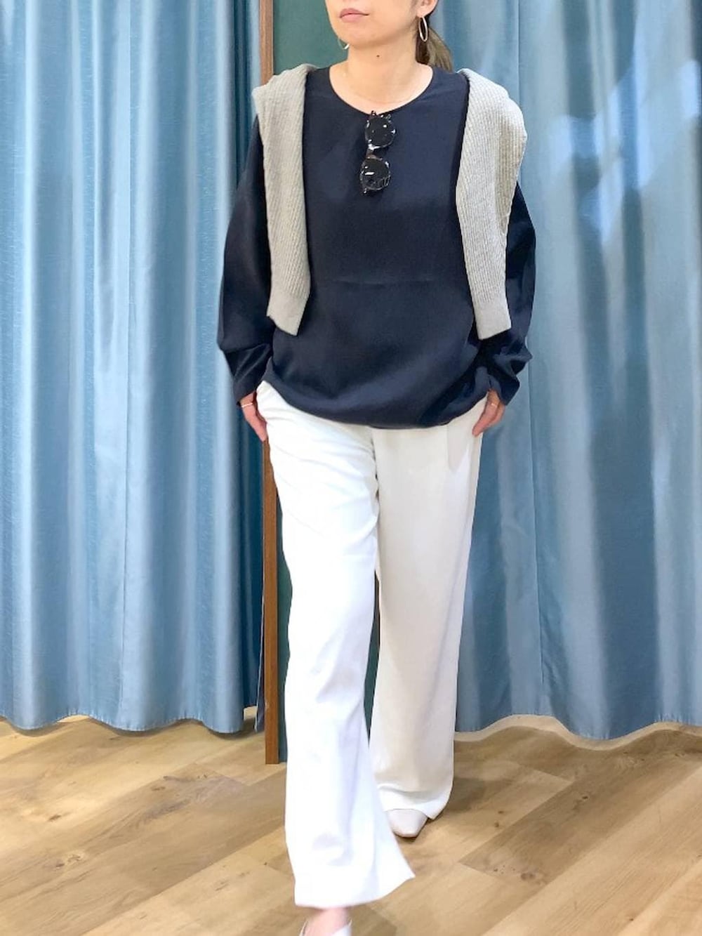 ホワイト系のスラックス、ベージュ系のカーディガン/ボレロ、ホワイト系のパンプスを着用したレディースの冬コーディネートの10枚目の写真