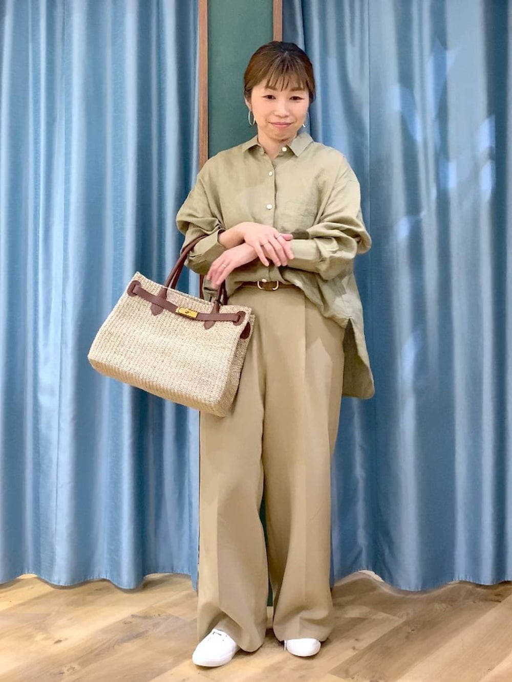 ベージュ系のシャツ/ブラウス、ブラウン系のスニーカー、ベージュ系のかごバッグを着用したレディースの春コーディネートの2枚目の写真