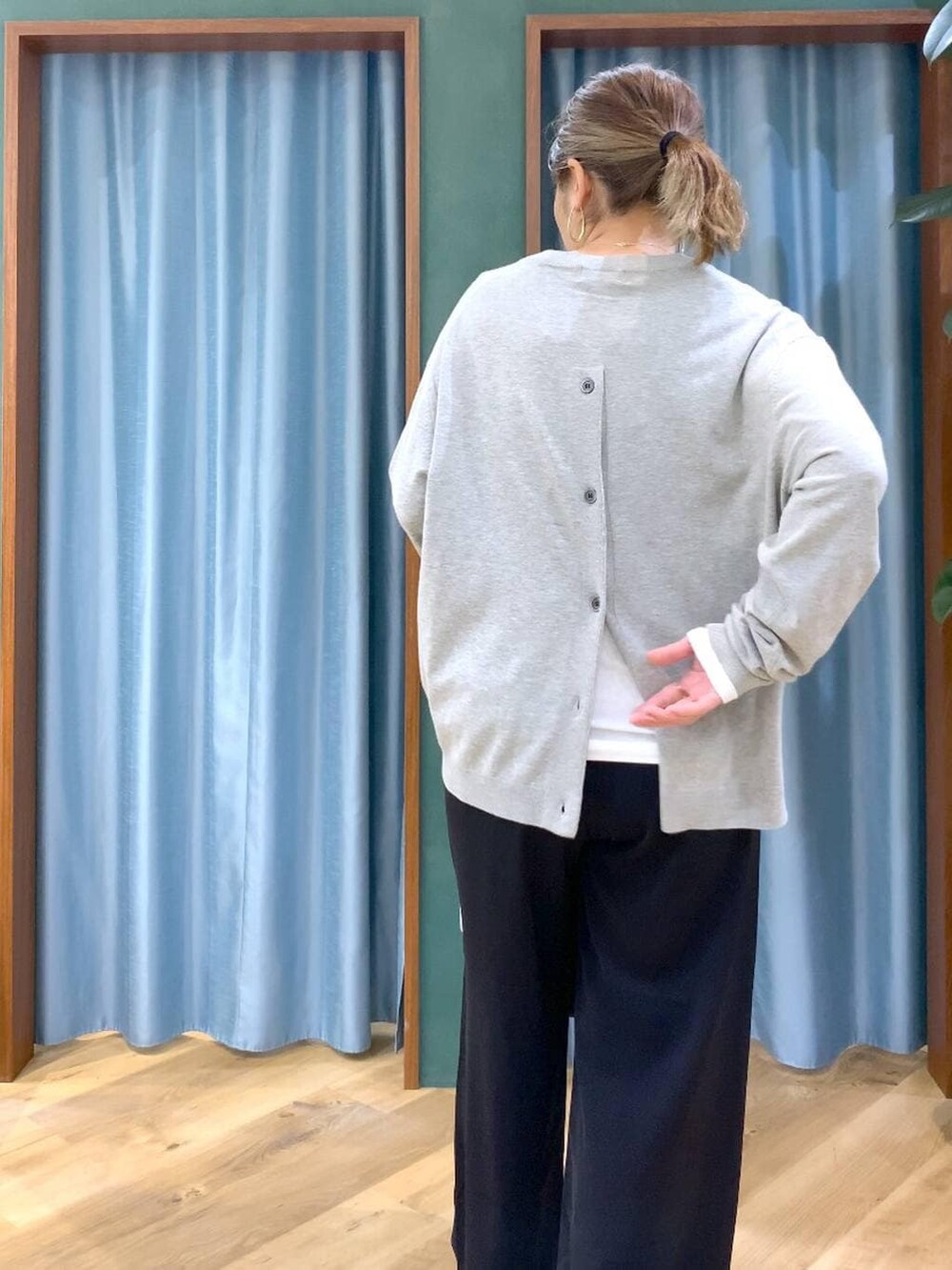 ブラック系のスラックス、ホワイト系のTシャツ/カットソー、グレー系のニット/セーターを着用したレディースの冬コーディネートの6枚目の写真