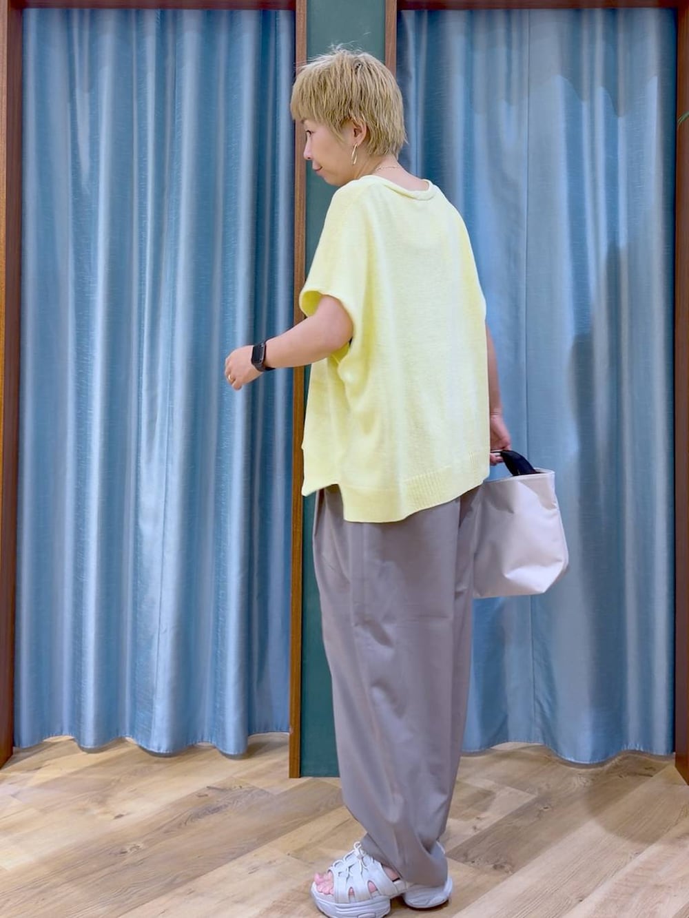 ホワイト系のトートバッグ、グレー系のサンダル、ブラウン系のその他パンツを着用したレディースの夏コーディネートの5枚目の写真