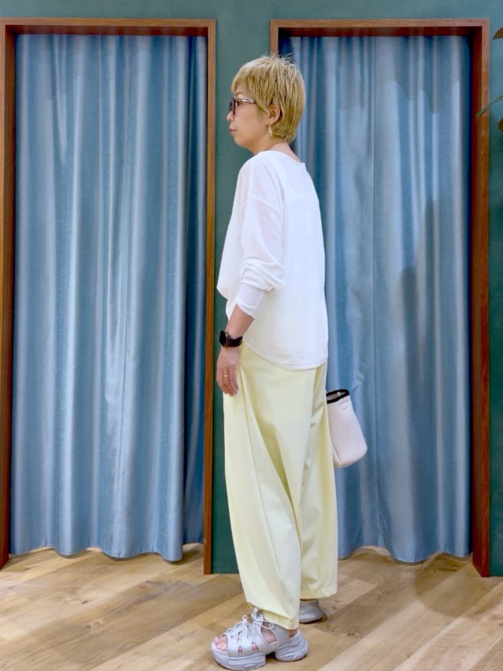 ホワイト系のタンクトップ、イエロー系のその他パンツ、ホワイト系のトートバッグを着用したレディースの夏コーディネートの4枚目の写真