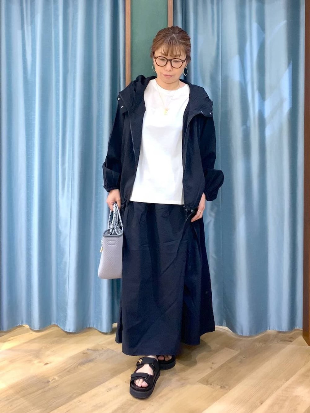 ホワイト系のTシャツ/カットソー、ブラック系のスカート、ブラック系のブルゾンを着用したレディースの春コーディネートの3枚目の写真