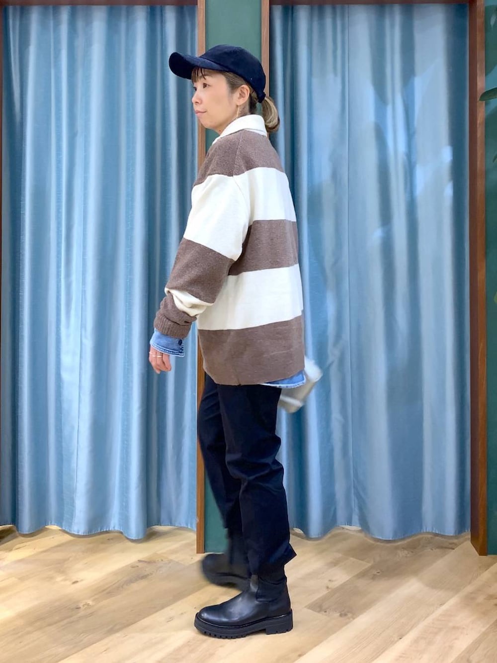 ブラック系のブーツ、ホワイト系のニット/セーター、ブルー系のシャツ/ブラウスを着用したレディースの冬コーディネートの4枚目の写真