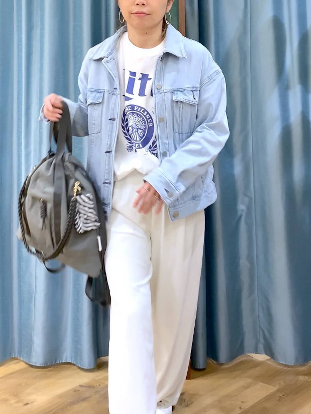 ホワイト系のスラックス、ブルー系のデニムジャケット、ホワイト系のTシャツ/カットソーを着用したレディースの冬コーディネートの7枚目の写真