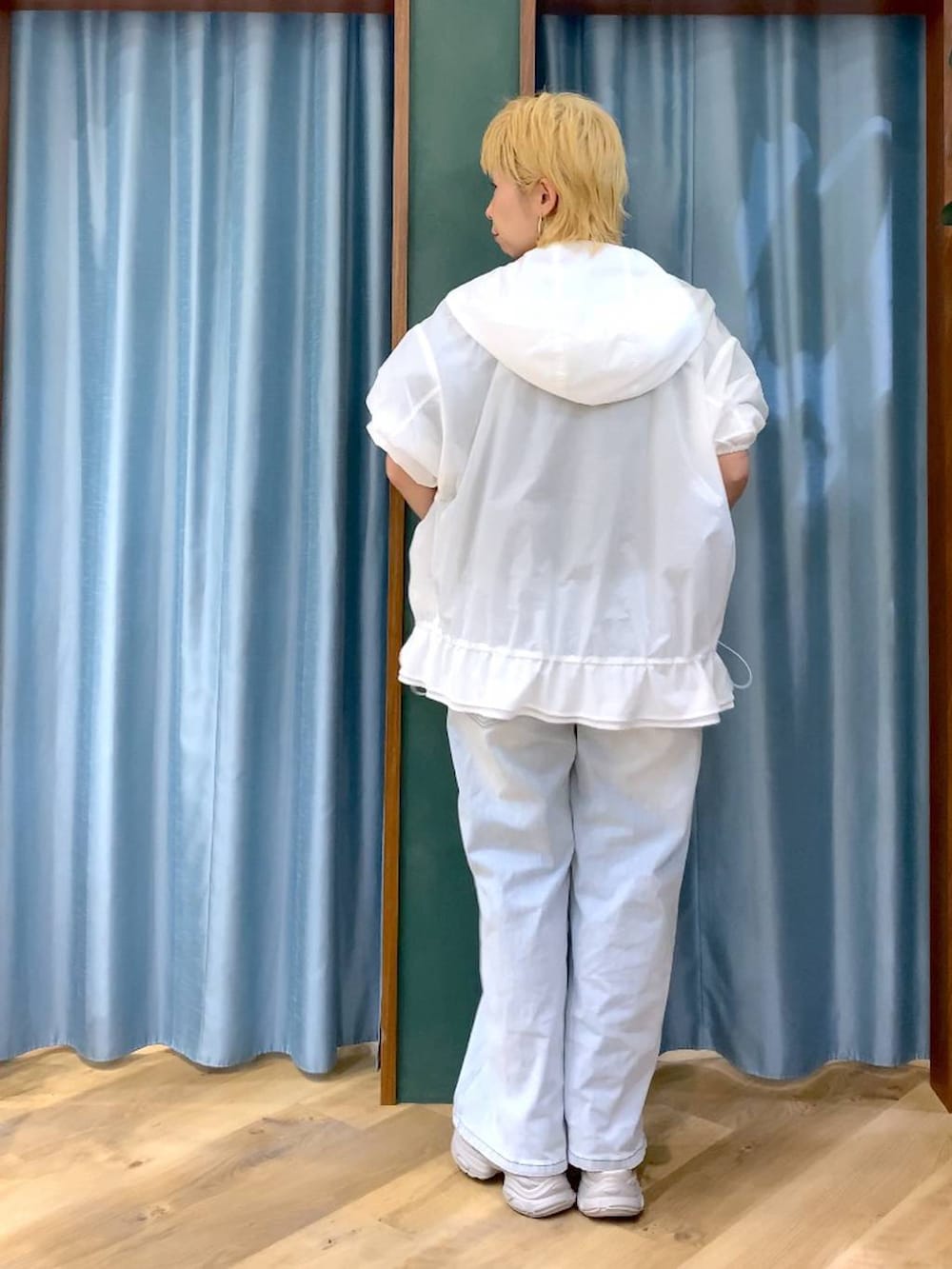 ブルー系のデニムパンツ、グレー系のサンダル、ホワイト系のブルゾンを着用したレディースの春コーディネートの6枚目の写真