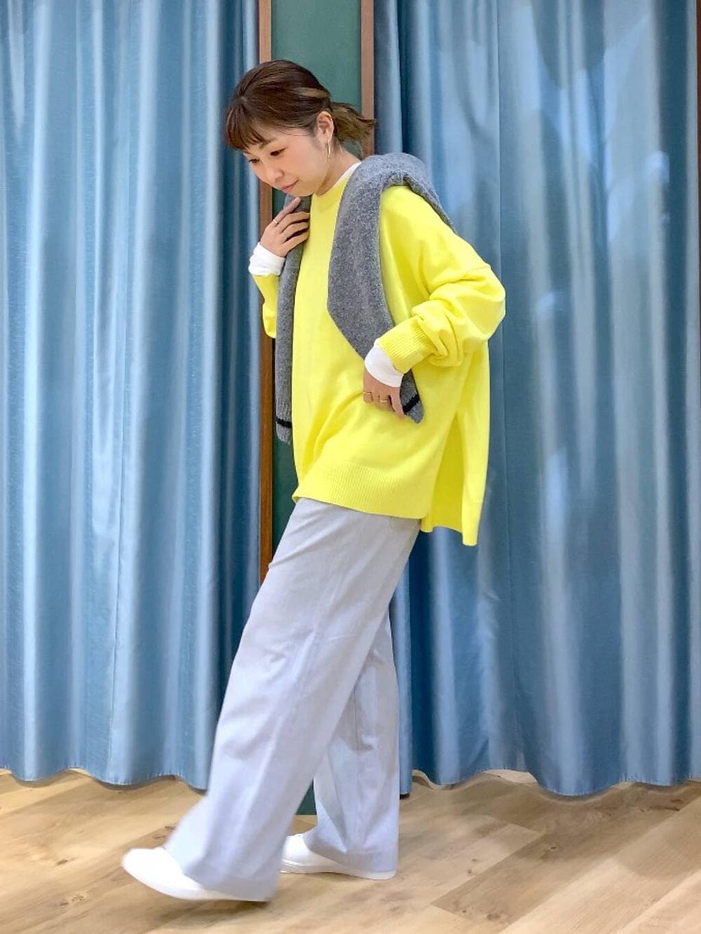 グレー系のカーディガン/ボレロ、ホワイト系のTシャツ/カットソー、イエロー系のニット/セーターを着用したレディースの秋コーディネートの2枚目の写真