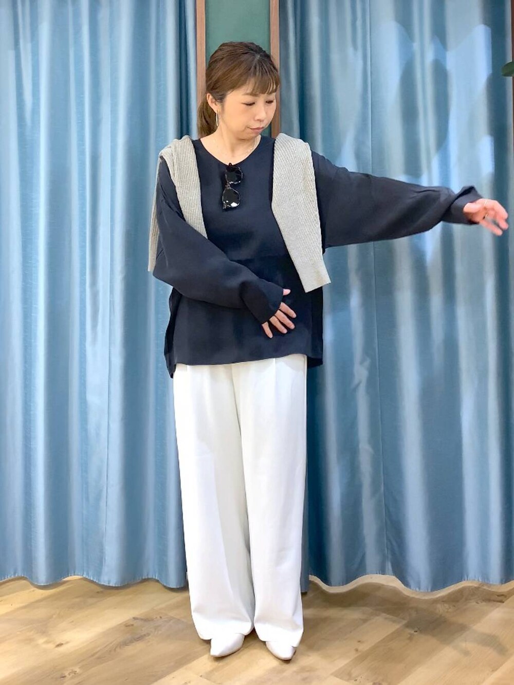 ホワイト系のスラックス、ベージュ系のカーディガン/ボレロ、ホワイト系のパンプスを着用したレディースの冬コーディネートの7枚目の写真