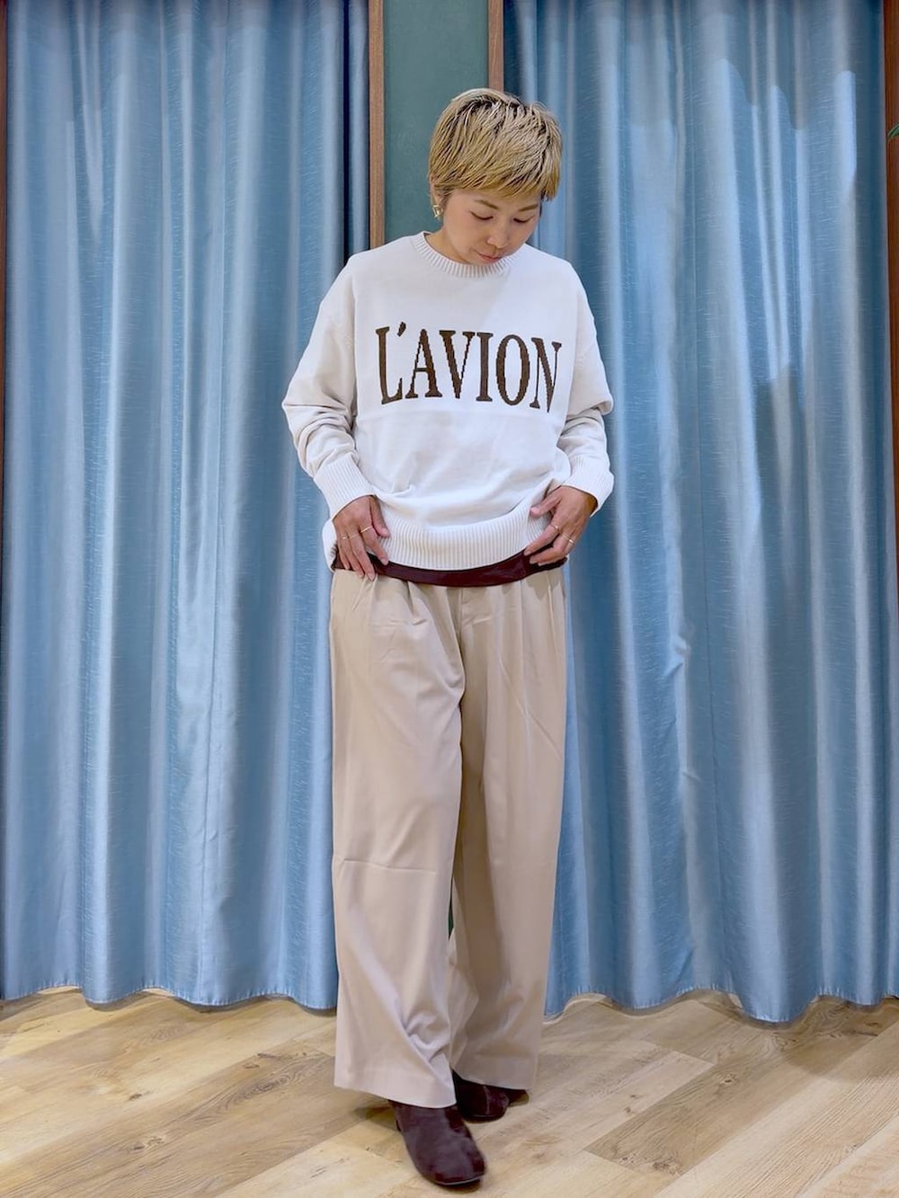 ブラウン系のTシャツ/カットソー、ブラウン系のブーツ、ホワイト系のニット/セーターを着用したレディースの秋コーディネートの5枚目の写真