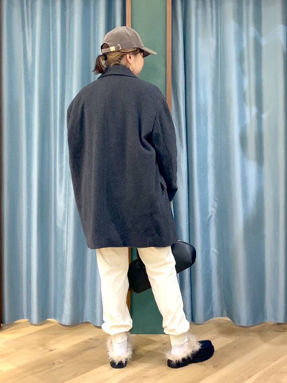 ブラック系のトートバッグ、ブルー系のシャツ/ブラウス、グレー系のベストを着用したレディースの秋コーディネートの5枚目の写真