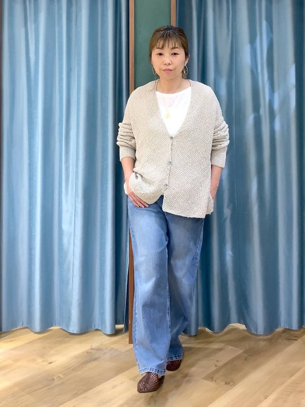 ブルー系のデニムパンツ、ホワイト系のTシャツ/カットソー、ベージュ系のカーディガン/ボレロを着用したレディースの春コーディネートの2枚目の写真