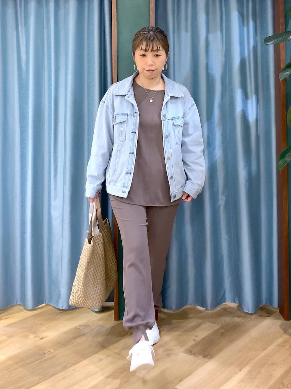 ブルー系のデニムジャケット、グリーン系のTシャツ/カットソー、ベージュ系のトートバッグを着用したレディースの冬コーディネートの4枚目の写真