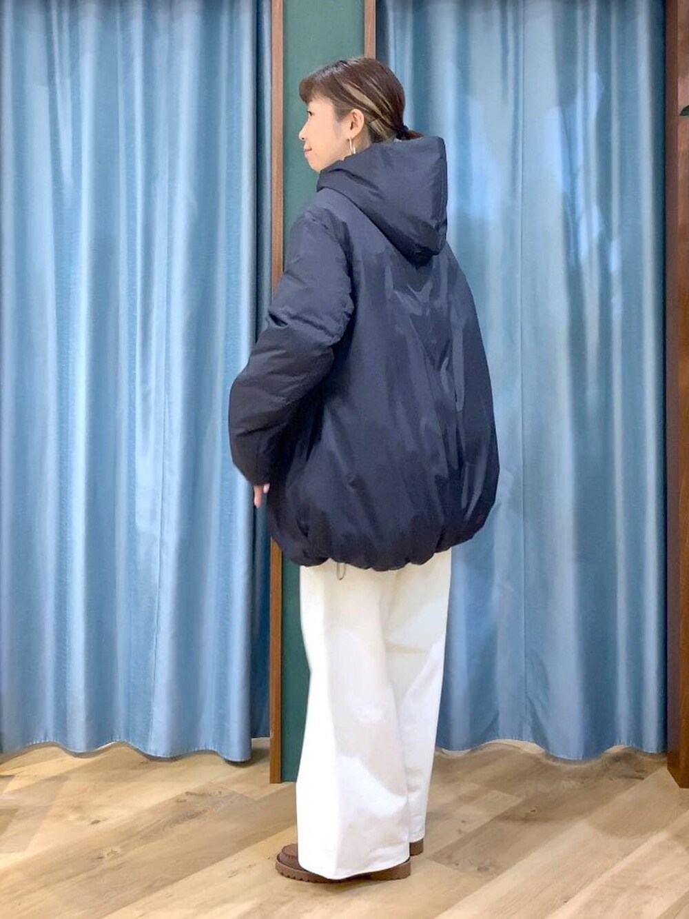 ブルー系のシャツ/ブラウス、ブラック系のダウンジャケット/コート、ブラウン系のローファーを着用したレディースの秋コーディネートの2枚目の写真