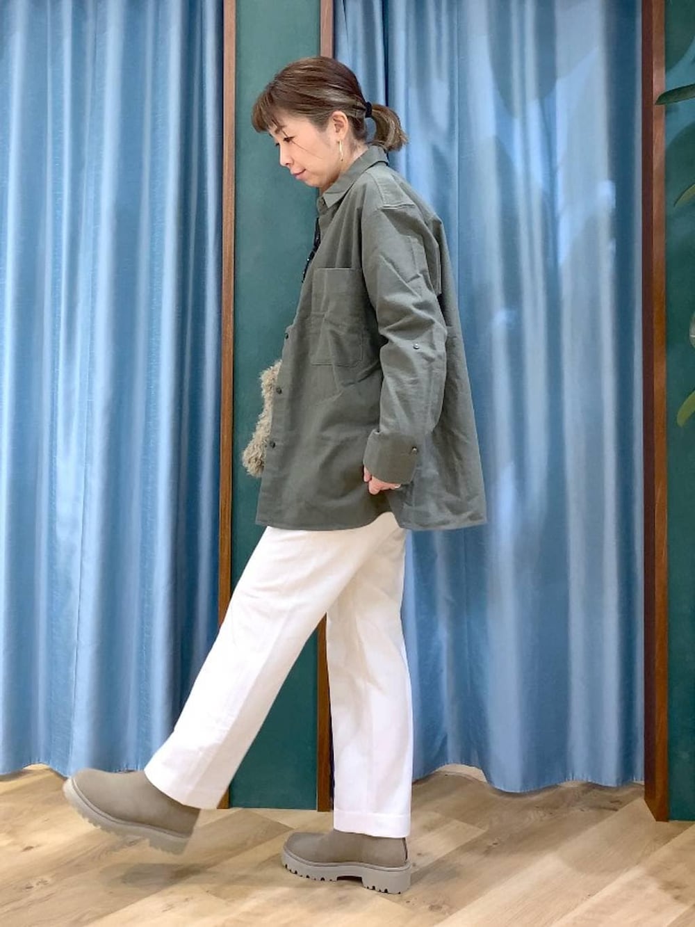 ベージュ系のハンドバッグ、ベージュ系のブーツ、ホワイト系のTシャツ/カットソーを着用したレディースの冬コーディネートの3枚目の写真