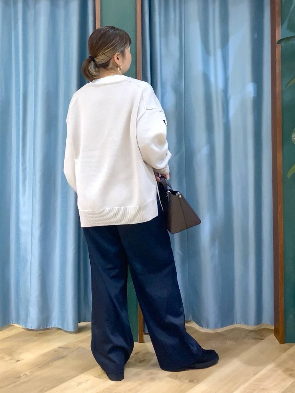 ベージュ系のニット/セーター、ブラック系のローファー、ホワイト系のTシャツ/カットソーを着用したレディースの秋コーディネートの5枚目の写真