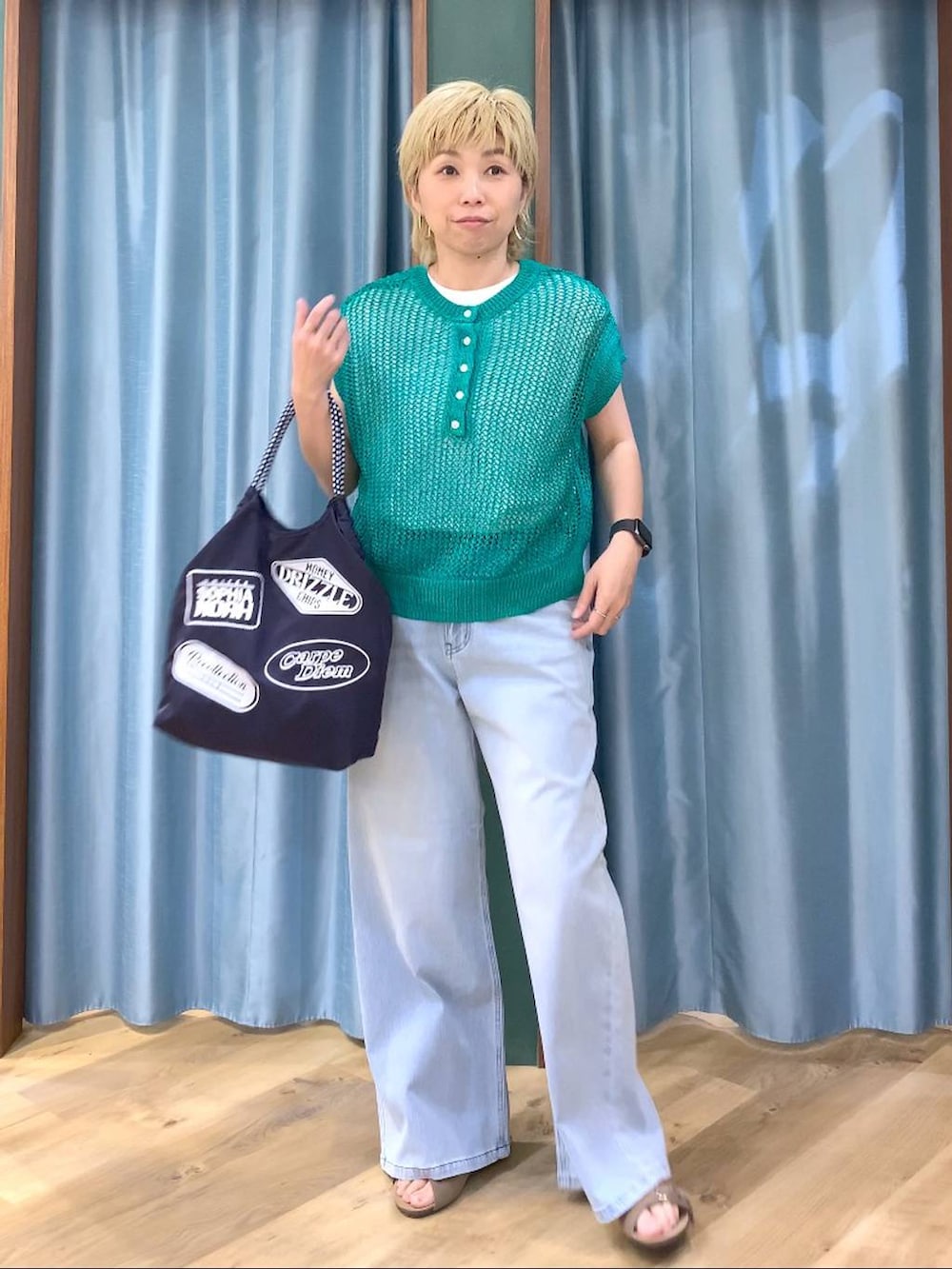 ホワイト系のTシャツ/カットソー、ブルー系のデニムパンツ、グリーン系のニット/セーターを着用したレディースの春コーディネートの3枚目の写真