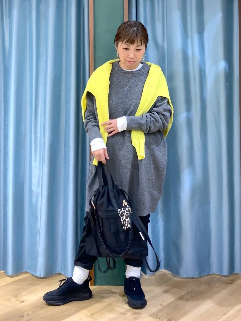 ブラック系のその他パンツ、ホワイト系のTシャツ/カットソー、イエロー系のニット/セーターを着用したレディースの秋コーディネートの3枚目の写真