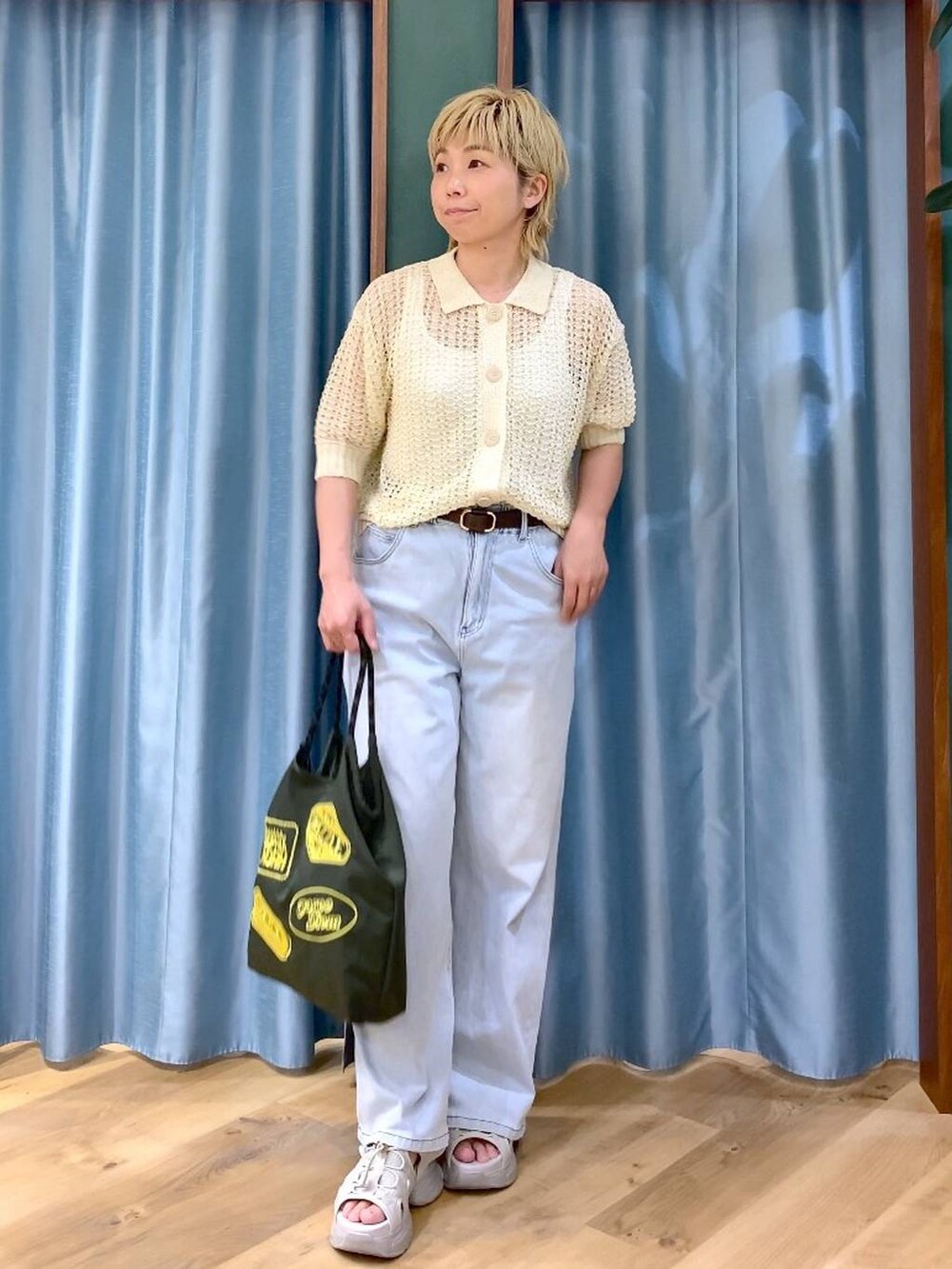 ホワイト系のタンクトップ、ブルー系のデニムパンツ、ホワイト系のニット/セーターを着用したレディースの夏コーディネートの2枚目の写真