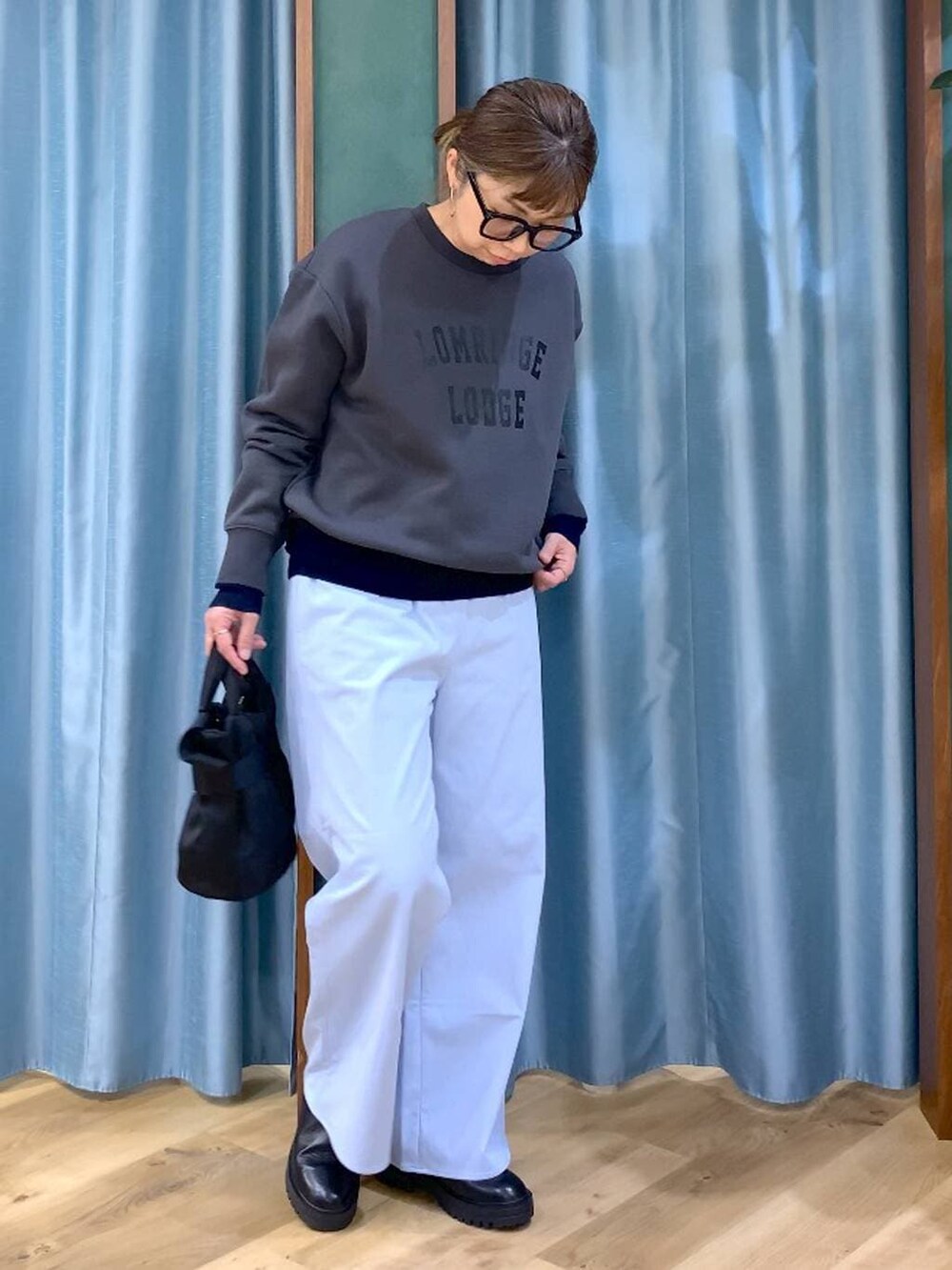 ブラック系のブーツ、ブラック系のショルダーバッグ、ブルー系のニット/セーターを着用したレディースの秋コーディネートの7枚目の写真