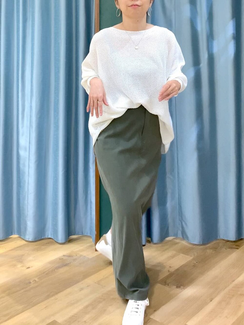 ホワイト系のニット/セーター、グリーン系のスカート、ブラウン系のスニーカーを着用したレディースの春コーディネートの7枚目の写真