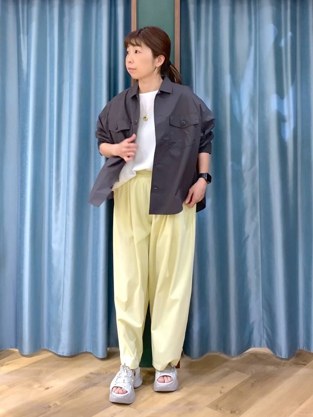 グレー系のシャツ/ブラウス、ホワイト系のTシャツ/カットソー、グレー系のサンダルを着用したレディースの春コーディネートの2枚目の写真