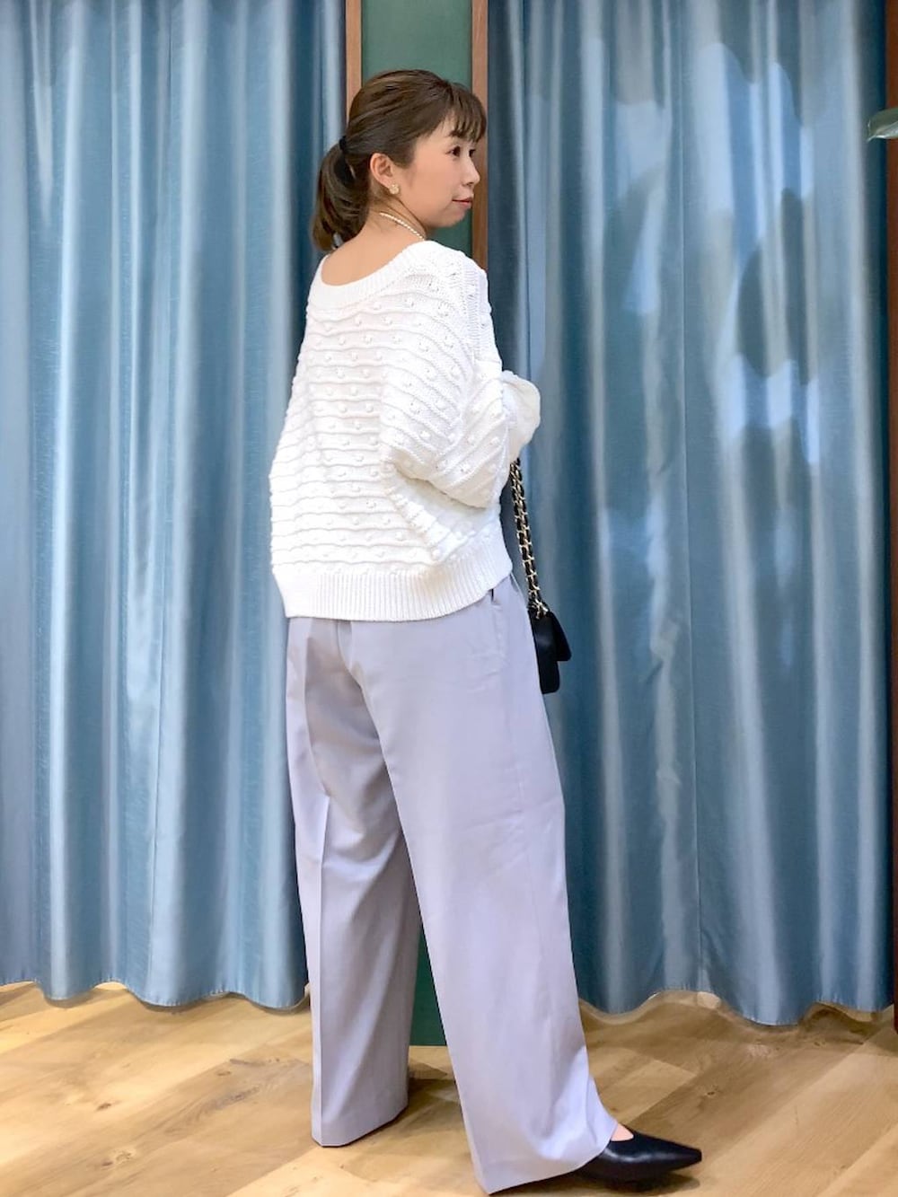 ホワイト系のニット/セーター、グレー系のその他パンツ、ブラック系のショルダーバッグを着用したレディースの冬コーディネートの5枚目の写真