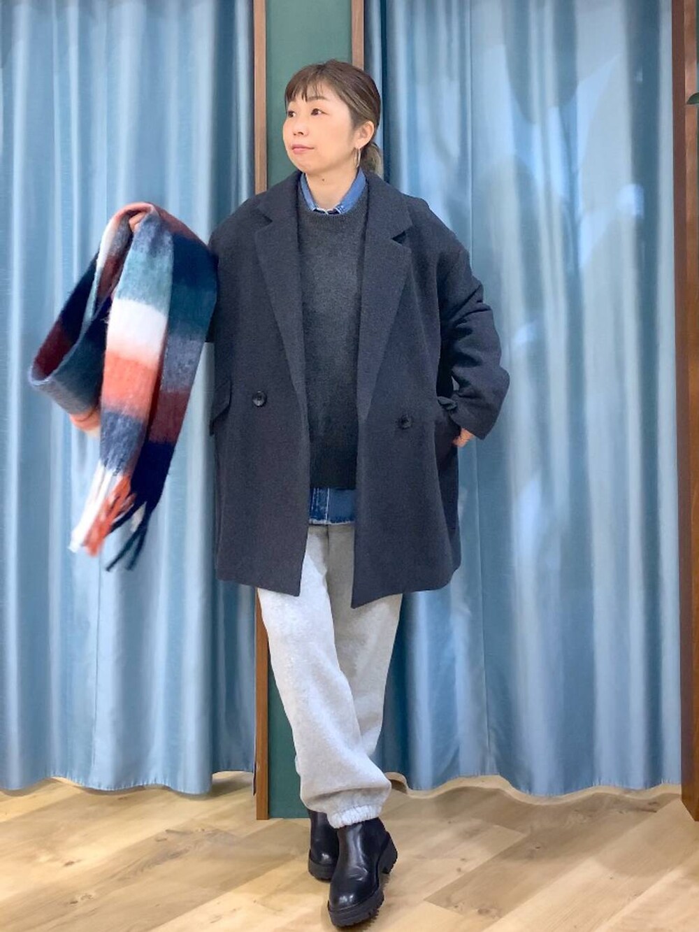 ブラック系のブーツ、ブルー系のシャツ/ブラウス、グレー系のニット/セーターを着用したレディースの秋コーディネートの3枚目の写真