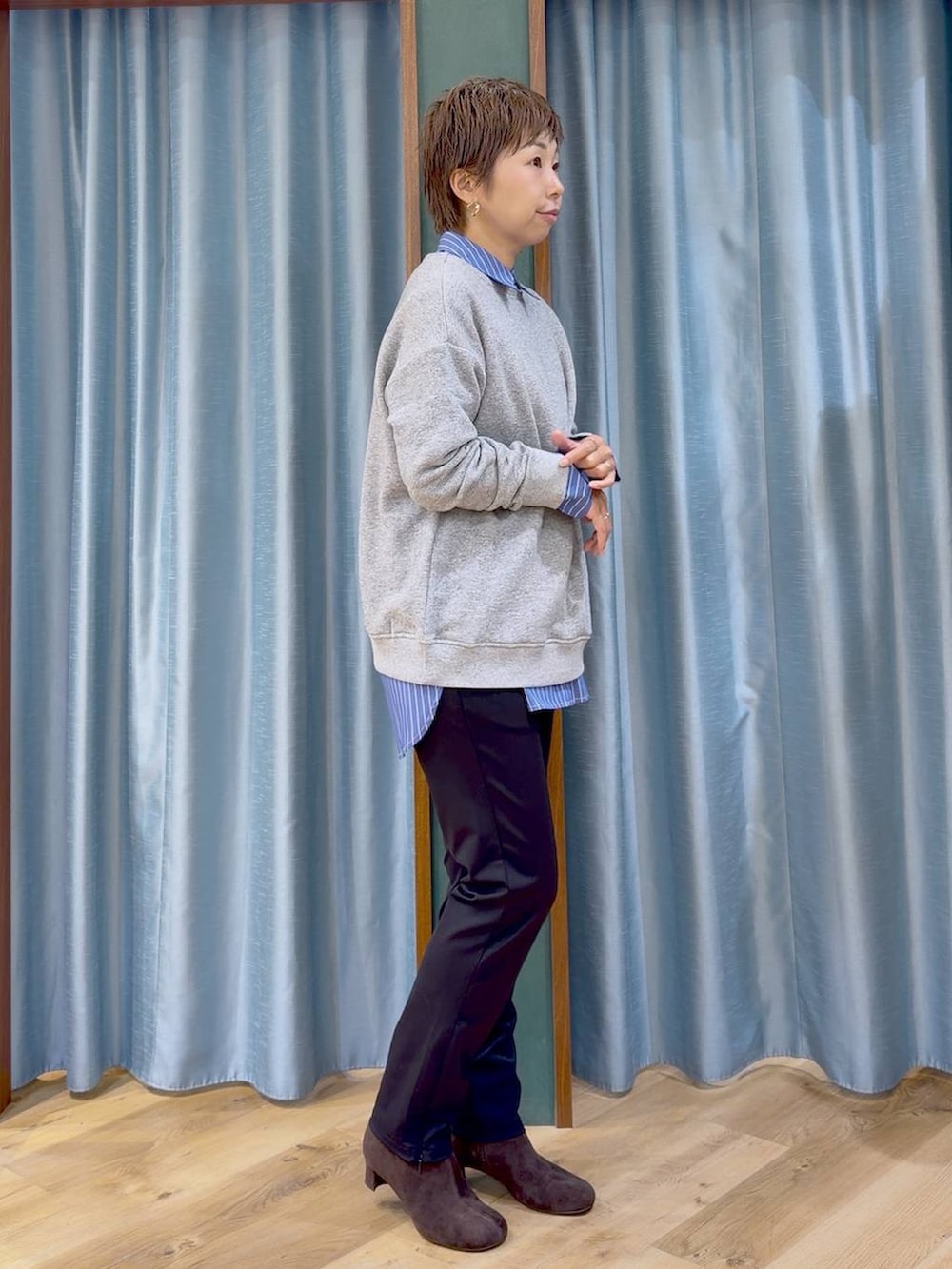 ブラック系のその他パンツ、ブラウン系のブーツ、ブルー系のシャツ/ブラウスを着用したレディースの秋コーディネートの3枚目の写真