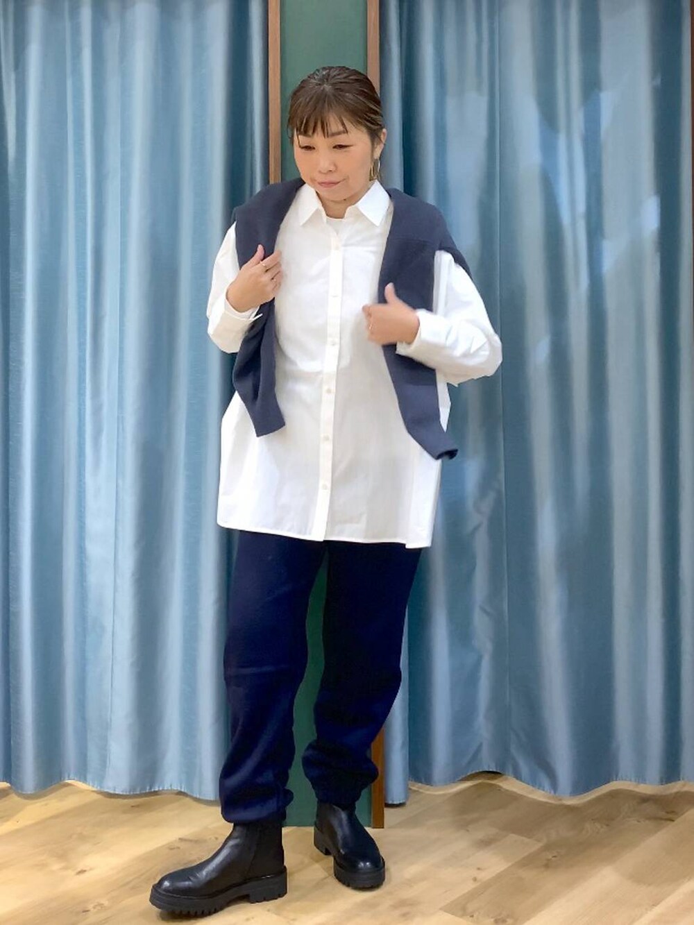 ブラック系のブーツ、ホワイト系のシャツ/ブラウス、グレー系のニット/セーターを着用したレディースの秋コーディネートの2枚目の写真