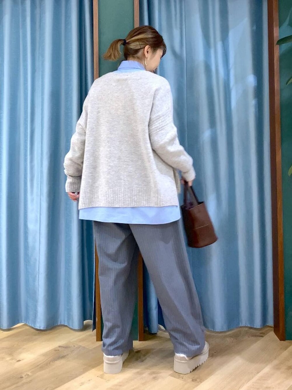 ブルー系のシャツ/ブラウス、ベージュ系のスリッポン、ベージュ系のニット/セーターを着用したレディースの冬コーディネートの6枚目の写真