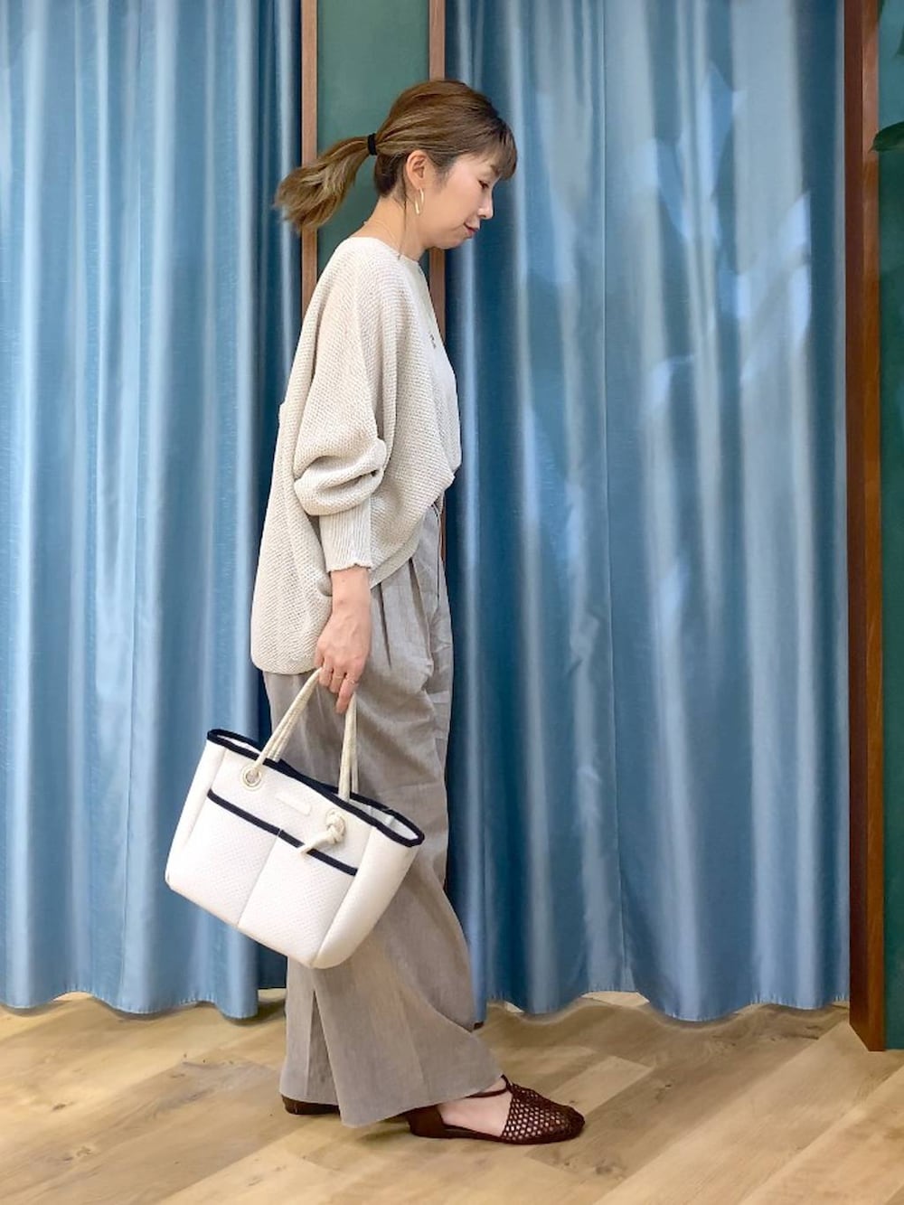 ベージュ系のニット/セーター、ホワイト系のトートバッグ、ベージュ系のその他パンツを着用したレディースの春コーディネートの3枚目の写真