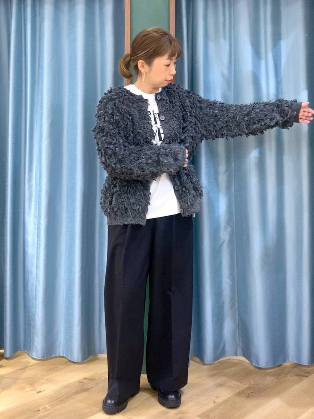 ブラック系のブーツ、ブラック系のスラックス、グレー系のカーディガン/ボレロを着用したレディースの冬コーディネートの4枚目の写真