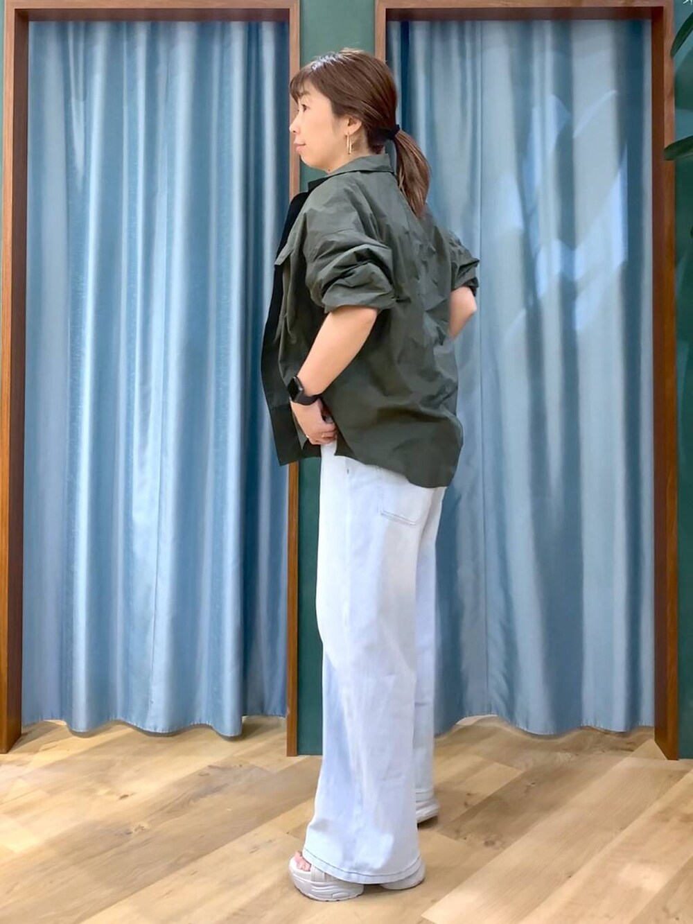 ブルー系のデニムパンツ、ホワイト系のTシャツ/カットソー、グレー系のサンダルを着用したレディースの春コーディネートの4枚目の写真
