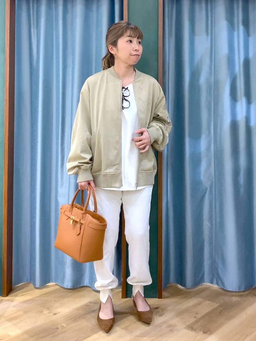 ベージュ系のMA-1、ホワイト系のTシャツ/カットソー、イエロー系のハンドバッグを着用したレディースの冬コーディネートの2枚目の写真