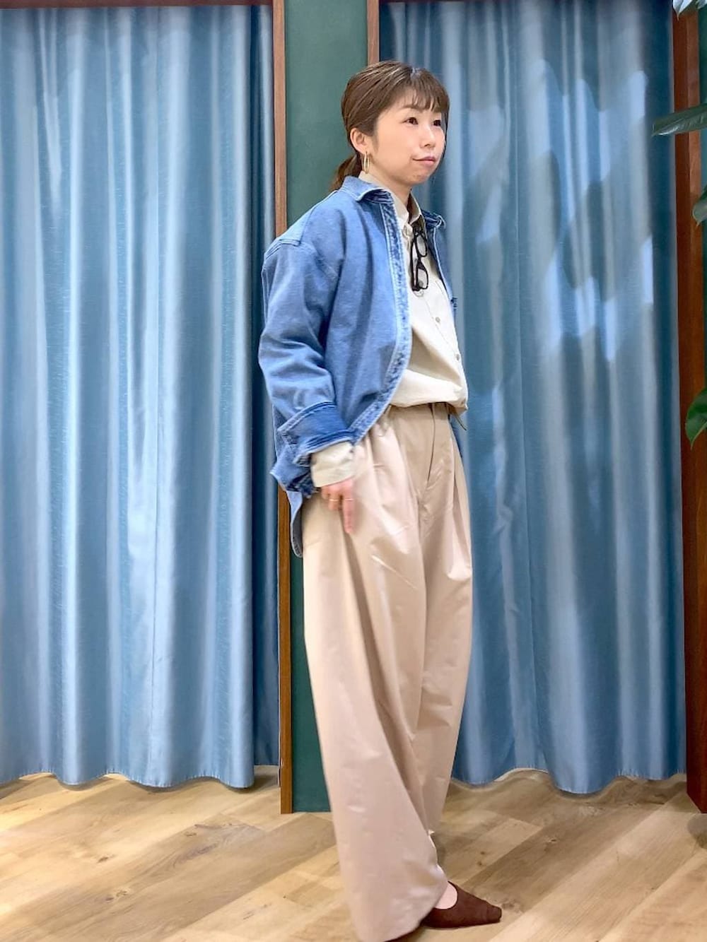 ブルー系のシャツ/ブラウス、ブラウン系のパンプス、ベージュ系のその他パンツを着用したレディースの冬コーディネートの2枚目の写真