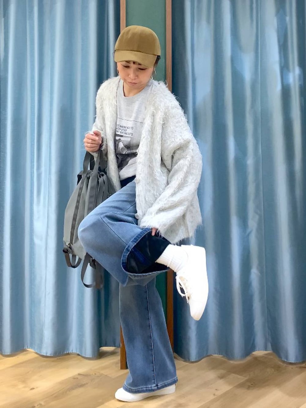 ブルー系のデニムパンツ、グレー系のTシャツ/カットソー、グレー系のバックパック/リュックを着用したレディースの秋コーディネートの7枚目の写真