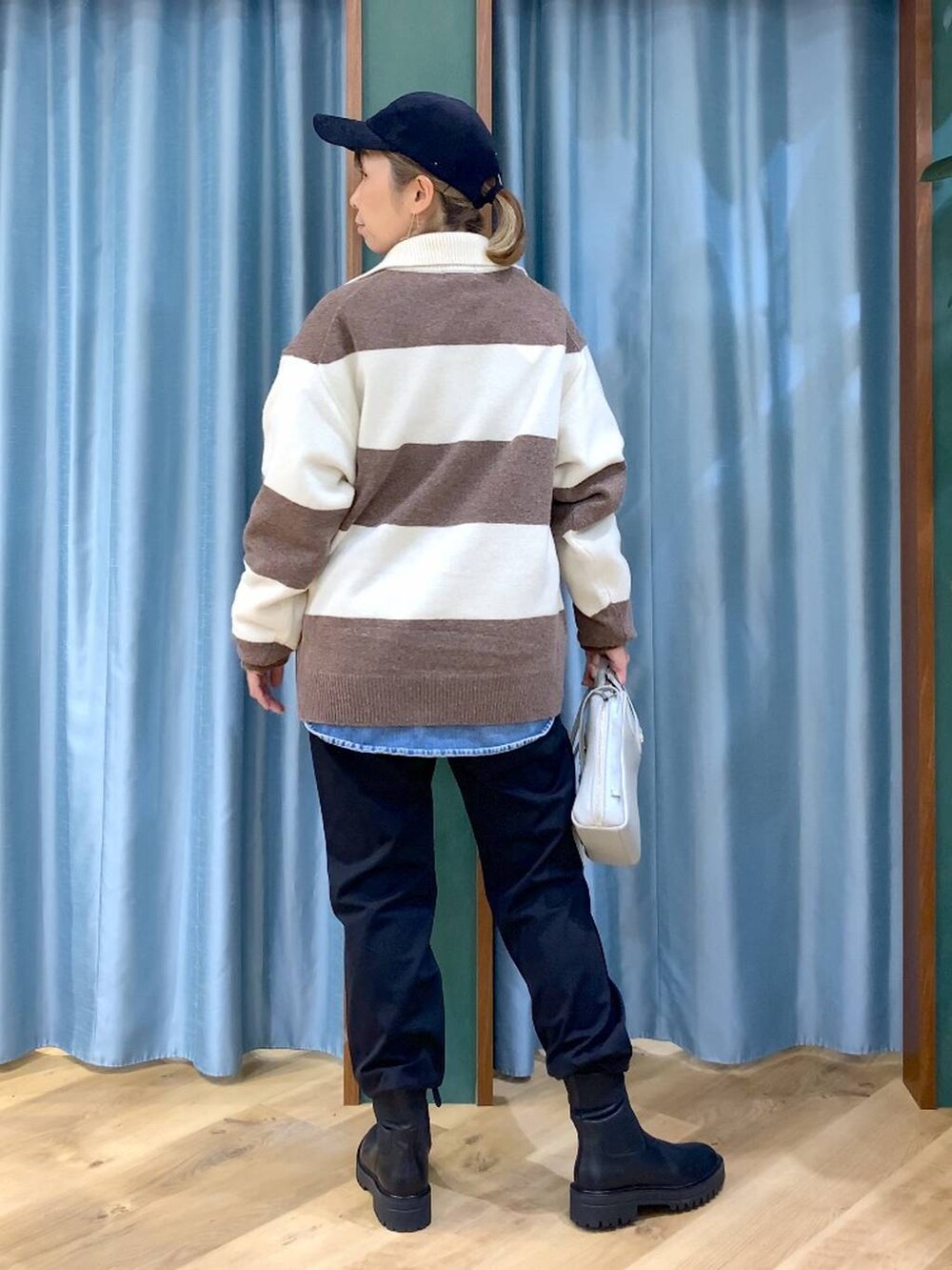 ブラック系のブーツ、ホワイト系のニット/セーター、ブルー系のシャツ/ブラウスを着用したレディースの冬コーディネートの8枚目の写真