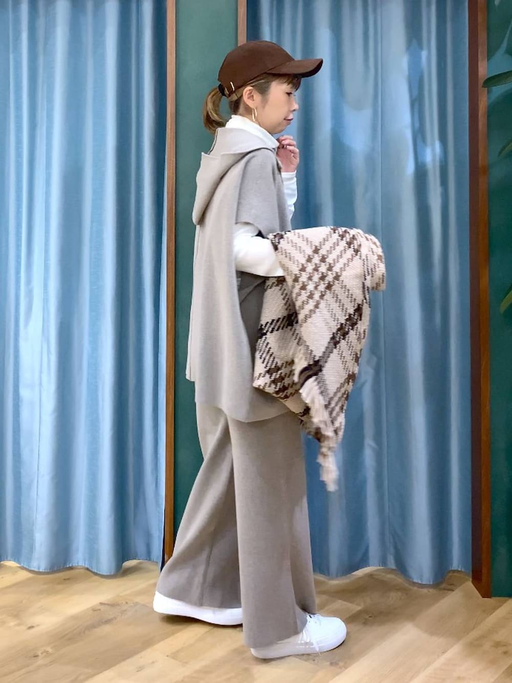 グレー系のベスト、グレー系のその他パンツ、ホワイト系のスニーカーを着用したレディースの冬コーディネートの2枚目の写真