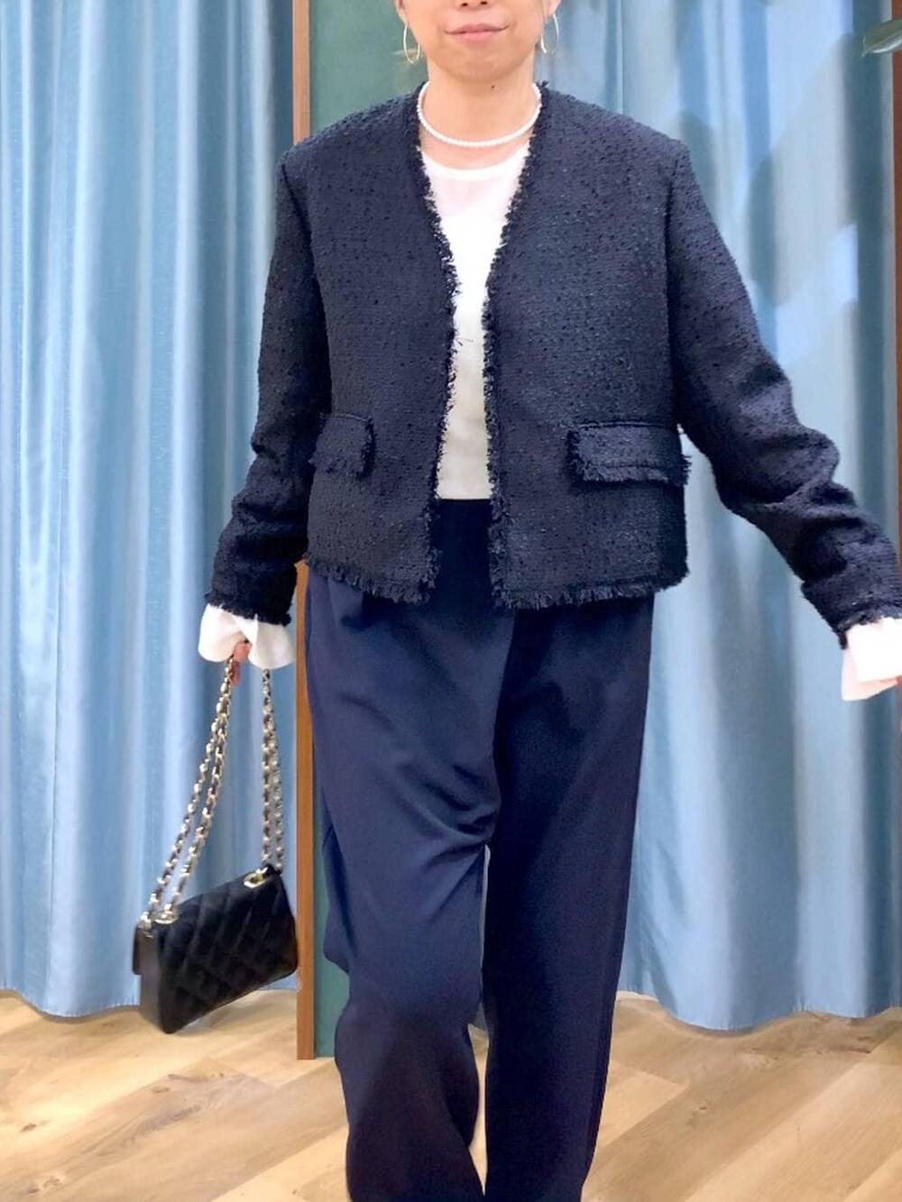 ホワイト系のニット/セーター、ブラック系のノーカラージャケット、ブルー系のその他パンツを着用したレディースの冬コーディネートの7枚目の写真