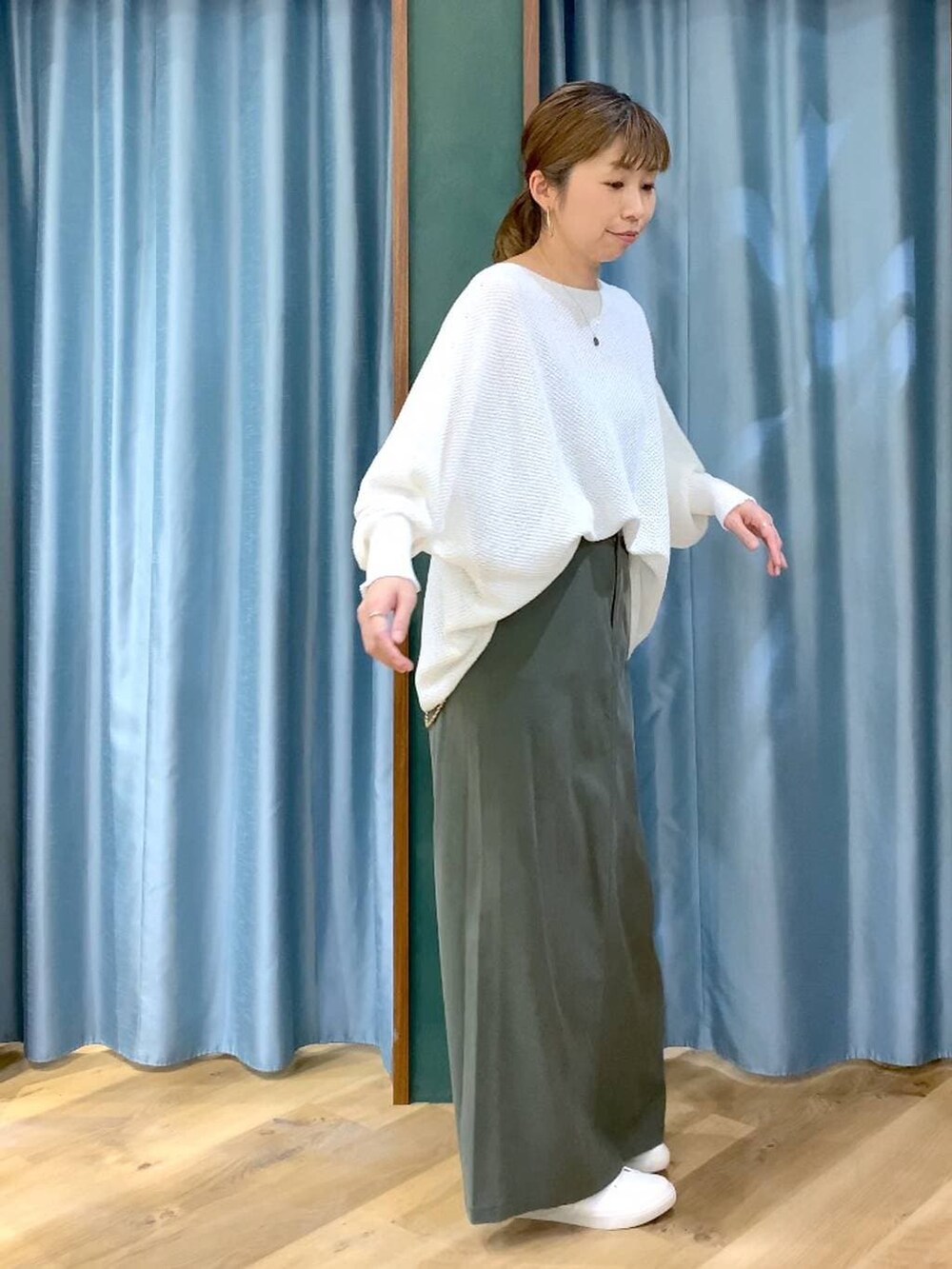 ホワイト系のニット/セーター、グリーン系のスカート、ブラウン系のスニーカーを着用したレディースの春コーディネートの5枚目の写真