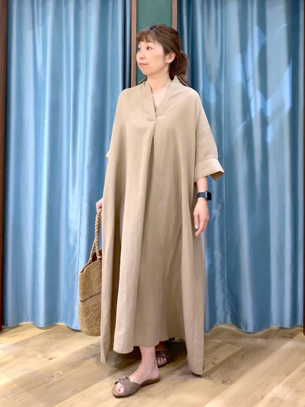 ベージュ系のワンピース、ブラウン系のサンダル、ベージュ系のかごバッグを着用したレディースの春コーディネートの3枚目の写真