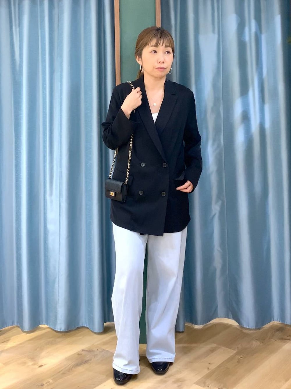 ホワイト系のその他トップス、ブルー系のデニムパンツ、ブラック系のテーラードジャケットを着用したレディースの冬コーディネートの4枚目の写真