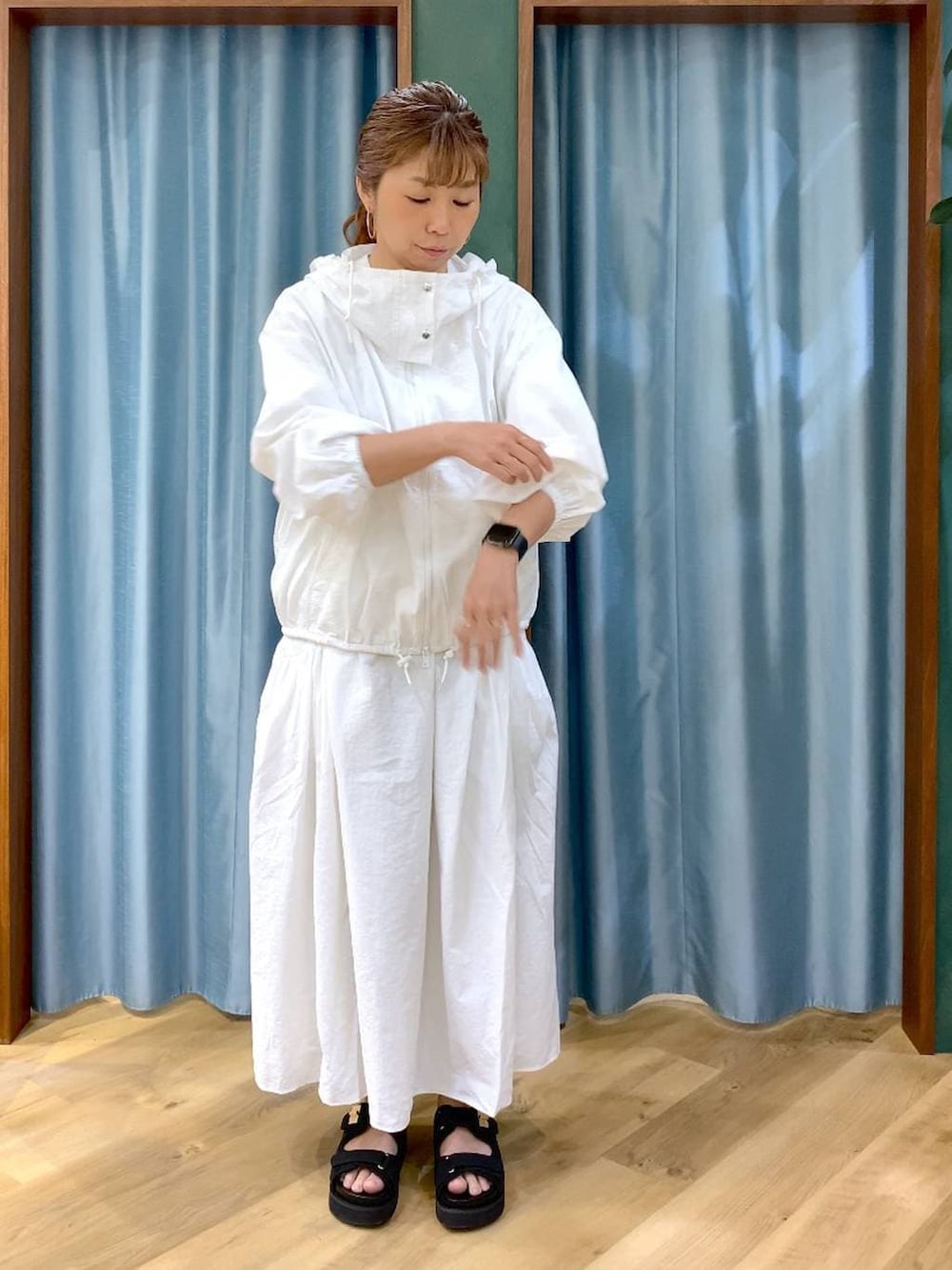 ホワイト系のスカート、ホワイト系のブルゾン、ブラック系のトートバッグを着用したレディースの春コーディネートの5枚目の写真