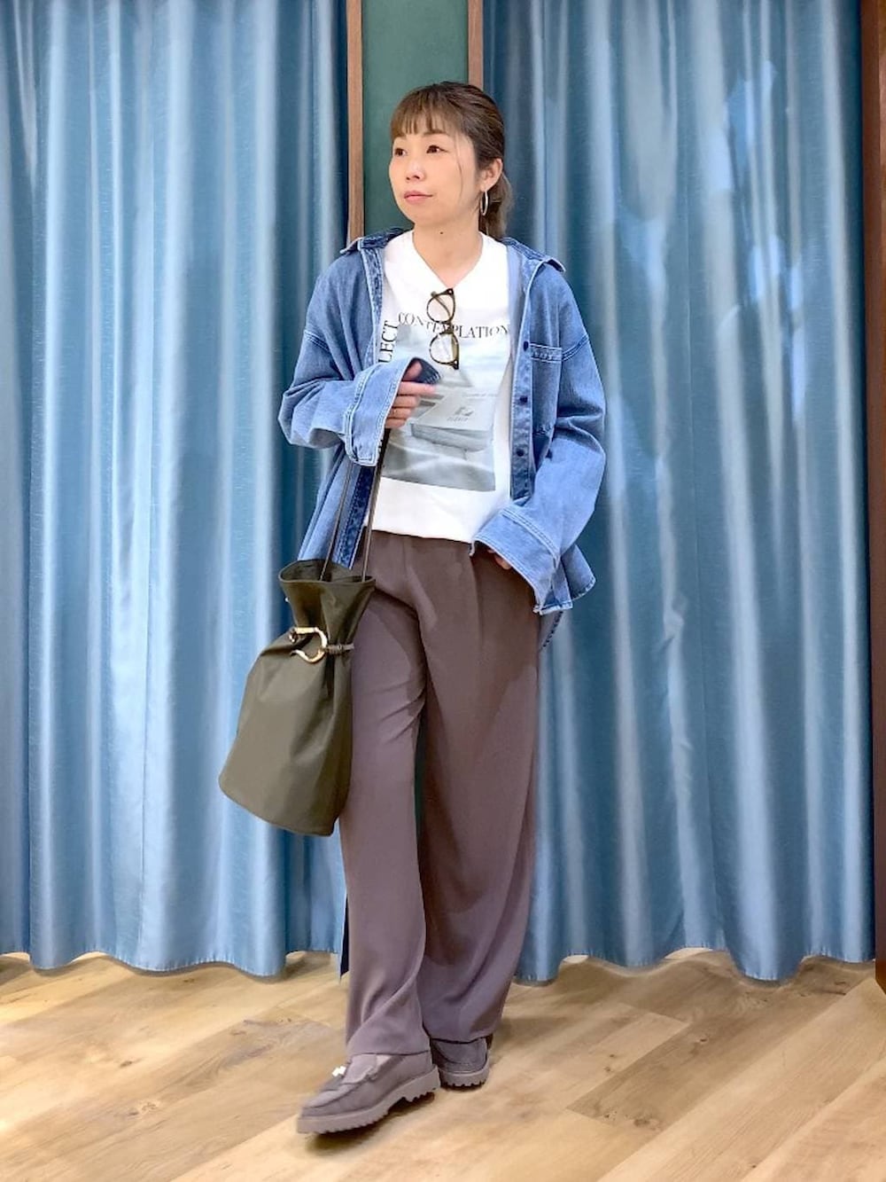 グリーン系のスラックス、ブルー系のシャツ/ブラウス、グレー系のローファーを着用したレディースの春コーディネートの3枚目の写真