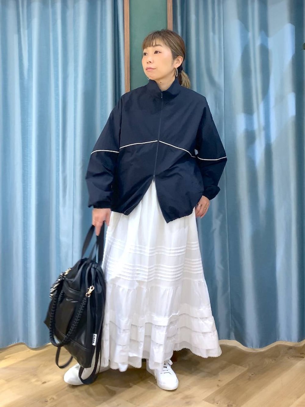 ブラック系のバックパック/リュック、ブルー系のナイロンジャケット、ブラウン系のスニーカーを着用したレディースの冬コーディネートの4枚目の写真