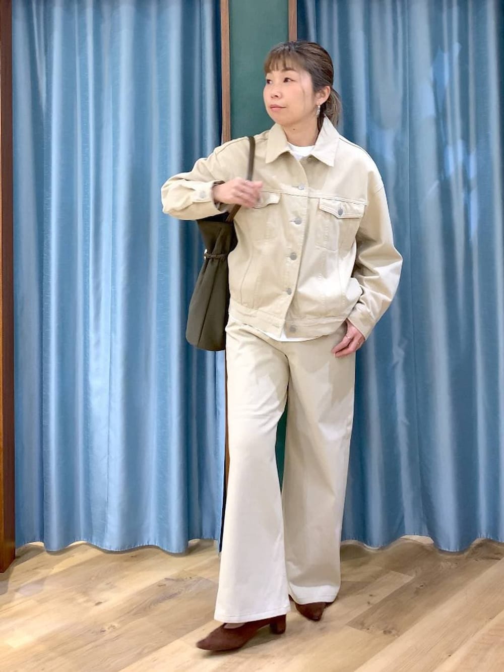 ブラウン系のパンプス、ベージュ系のデニムパンツ、ベージュ系のデニムジャケットを着用したレディースの春コーディネートの2枚目の写真