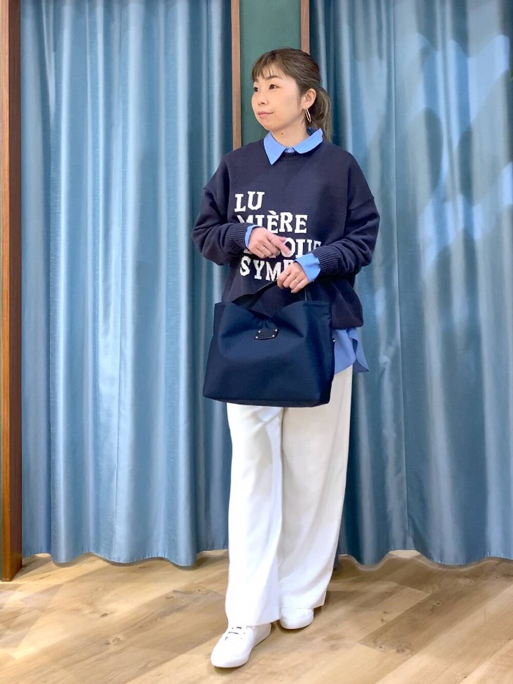 ホワイト系のスラックス、ブルー系のトートバッグ、グレー系のニット/セーターを着用したレディースの冬コーディネートの3枚目の写真