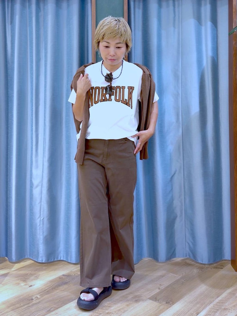 ブラック系のサンダル、ブラウン系のカーディガン/ボレロ、ホワイト系のTシャツ/カットソーを着用したレディースの夏コーディネートの2枚目の写真