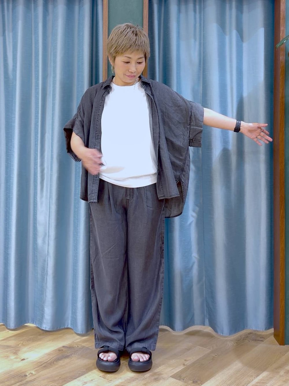 ブラック系のサンダル、ホワイト系のTシャツ/カットソー、ブラック系のシャツ/ブラウスを着用したレディースの夏コーディネートの4枚目の写真