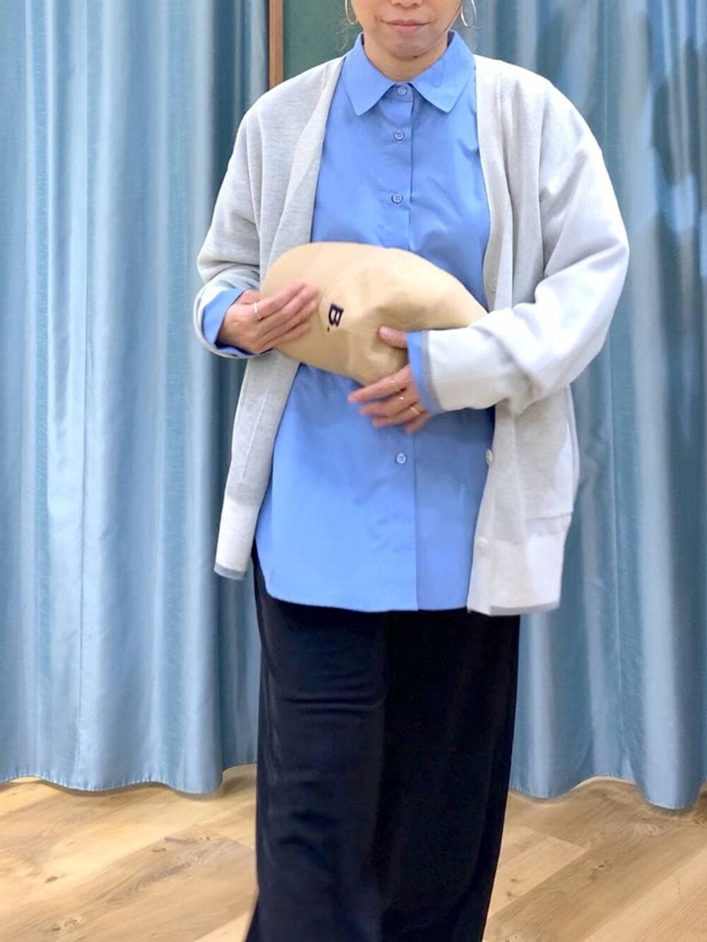 ブラック系のスラックス、ホワイト系のカーディガン/ボレロ、ブルー系のシャツ/ブラウスを着用したレディースの冬コーディネートの6枚目の写真