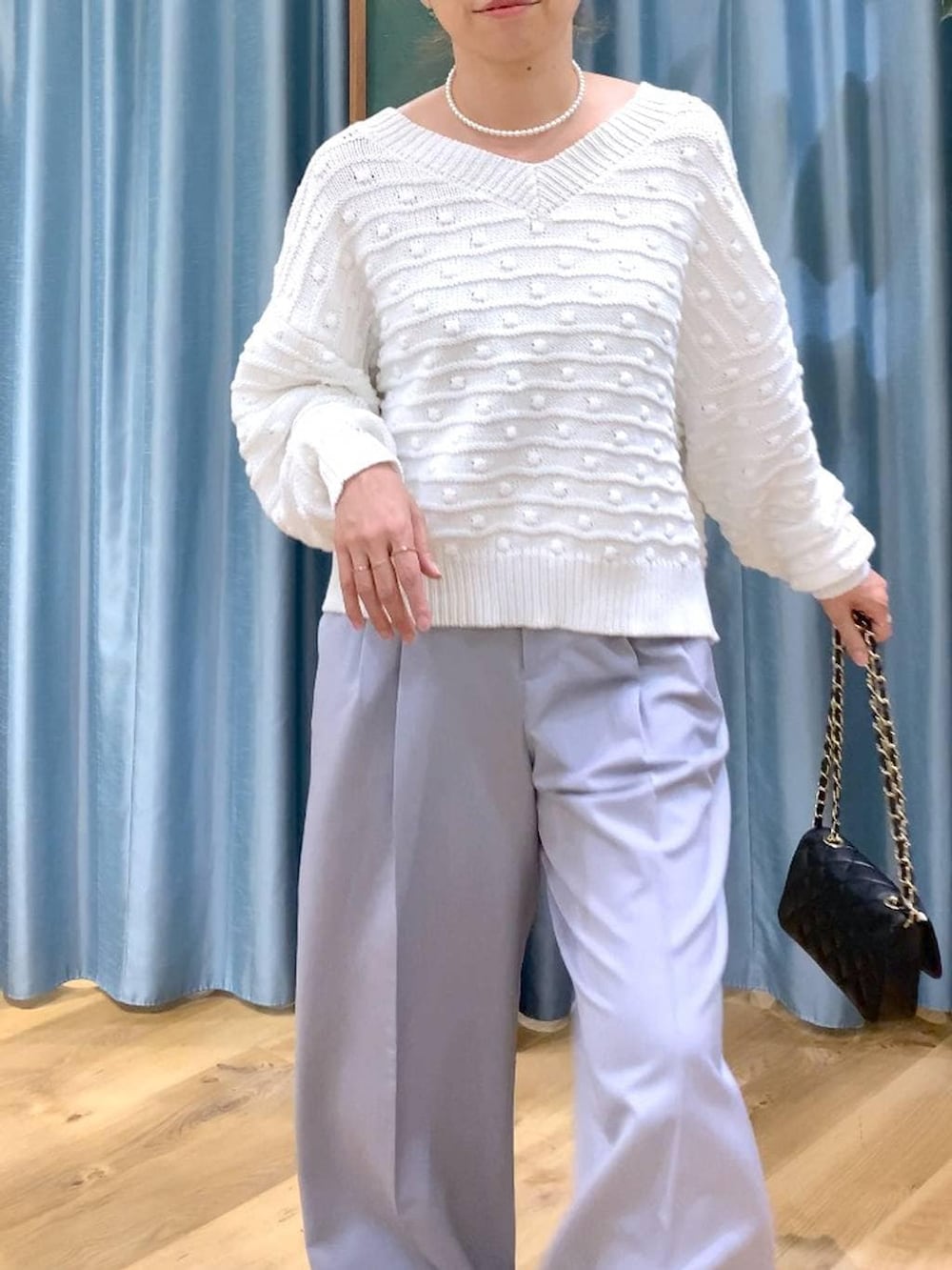 ホワイト系のニット/セーター、グレー系のその他パンツ、ブラック系のショルダーバッグを着用したレディースの冬コーディネートの7枚目の写真